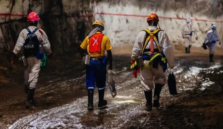 Prioritize safety with proper gear. Miners wearing hard hats, safety goggles, and respirators working in a mine.