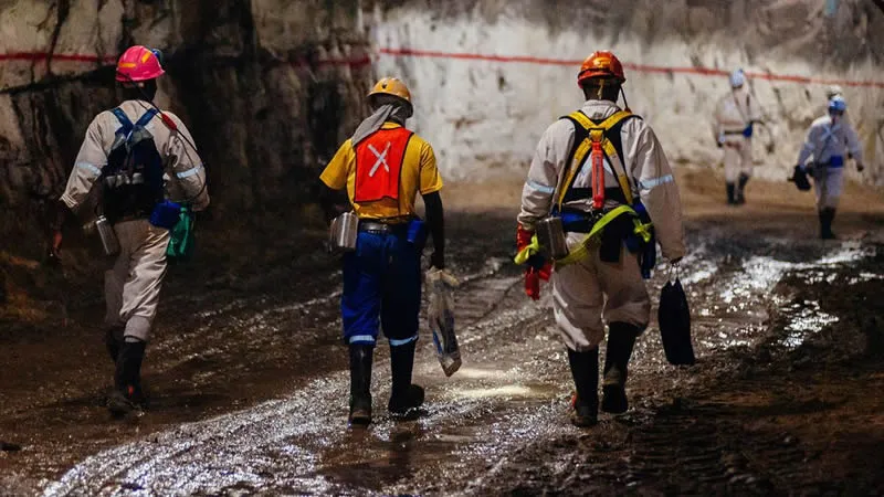Prioritize safety with proper gear. Miners wearing hard hats, safety goggles, and respirators working in a mine.