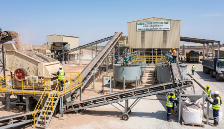 Wide-angle view of the Kangimi Lithium Processing Plant in Kaduna, showing conveyor belts, crushing machinery, filtration tanks, and workers in safety gear processing mineral ore.